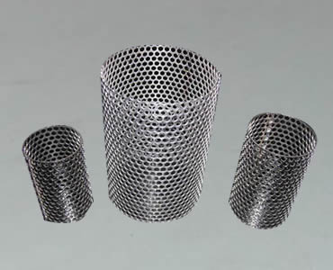 Three perforated filter tubes with oval perforated holes stand on black ground.